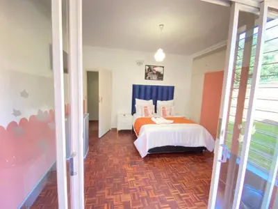 a bedroom with a bed and a tub in it at Ranx Guest House in Pretoria