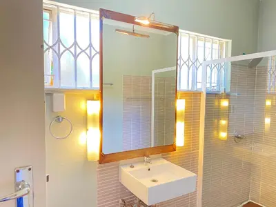 a bathroom with a sink and a mirror at Ranx Guest House in Pretoria