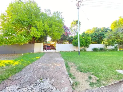 an empty driveway in a yard with a house at Ranx Guest House in Pretoria