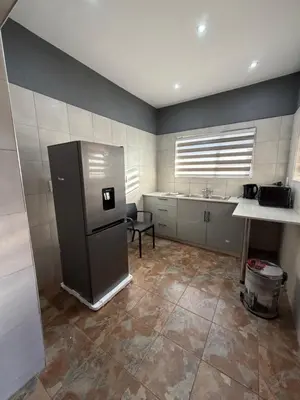 a kitchen with a refrigerator and a sink at Royal nest Sibasa in Thohoyandou