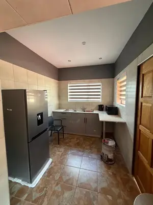 a kitchen with a refrigerator and a sink in it at Royal nest Sibasa in Thohoyandou