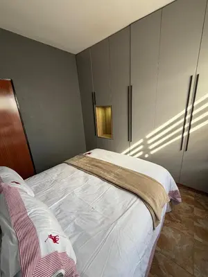 a bedroom with a bed with white sheets at Royal nest Sibasa in Thohoyandou