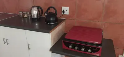 a kitchen counter with a tea kettle and a red box at Villa at Wekker Upstairs in Pretoria