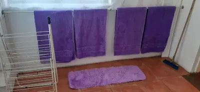 a bathroom with purple shower curtains and purple mats at Villa at Wekker Upstairs in Pretoria
