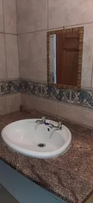 a white sink in a bathroom with a mirror at Villa at Wekker Upstairs in Pretoria