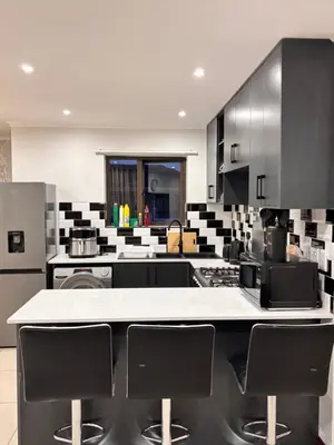 a large kitchen with black and white appliances at Adilo Villa Midrand Hill of Good Hope 2 in Midrand