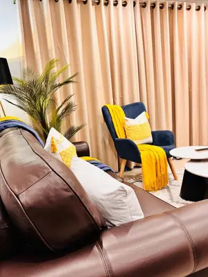 a living room with a brown leather couch and chairs at Adilo Villa Midrand Hill of Good Hope 2 in Midrand