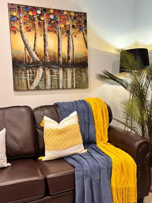 a living room with a couch with a yellow blanket at Adilo Villa Midrand Hill of Good Hope 2 in Midrand