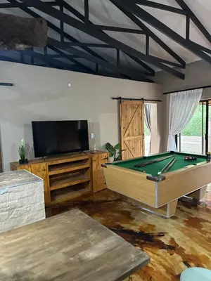 a room with a pool table and a flat screen tv at Wonderviews Hedgehog in Marloth Park