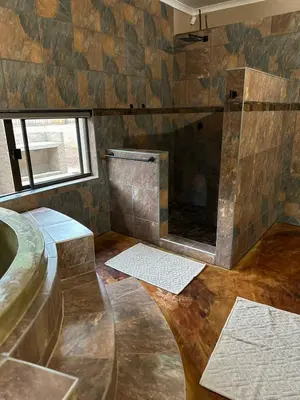 a bathroom with a tub and a sink and a mirror at Wonderviews Hedgehog in Marloth Park