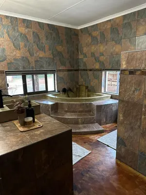 a bathroom with a tub in the middle of a room at Wonderviews Hedgehog in Marloth Park