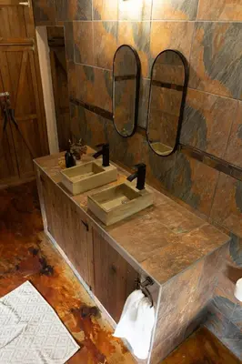 a bathroom with two sinks and two mirrors at Wonderviews Hedgehog in Marloth Park