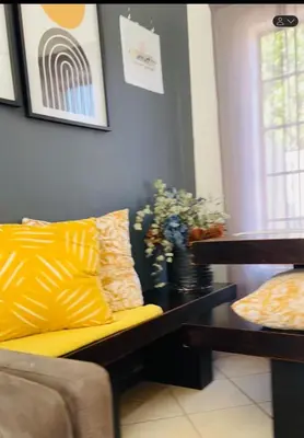 a living room with a yellow couch and a table at 2 Bed Townhouse, Quiet and Stylish in Pretoria