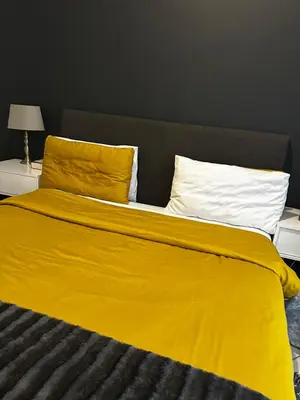 a bed with a yellow blanket and two pillows at 2 Bed Townhouse, Quiet and Stylish in Pretoria