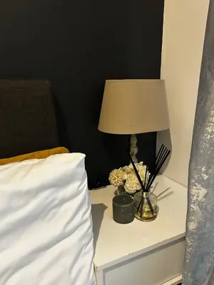 a lamp on a night stand next to a bed at 2 Bed Townhouse, Quiet and Stylish in Pretoria