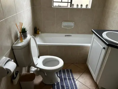 a bathroom with a toilet and a tub and a sink at 2 Bed Townhouse, Quiet and Stylish in Pretoria
