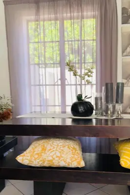 a table with a pillow in front of a window at 2 Bed Townhouse, Quiet and Stylish in Pretoria
