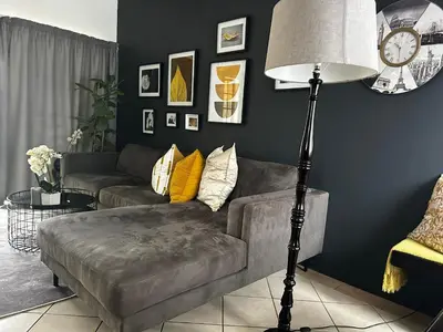 a living room with a couch and a floor lamp at 2 Bed Townhouse, Quiet and Stylish in Pretoria