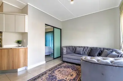 a living room with a couch and a table at Stylish Modern 1 Bedroom in Midrand