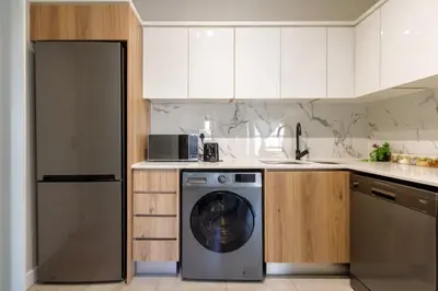 a kitchen with a washing machine in a kitchen at Stylish Modern 1 Bedroom in Midrand
