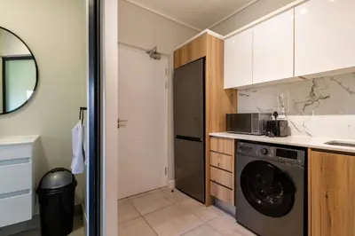 a kitchen with a washer and dryer in a room at Stylish Modern 1 Bedroom in Midrand