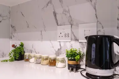 a kitchen counter with jars of honey and a toaster at Stylish Modern 1 Bedroom in Midrand
