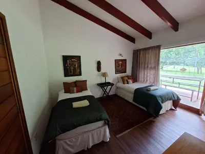 a bedroom with two beds and a window with a view at Naledi-Africa in Centurion