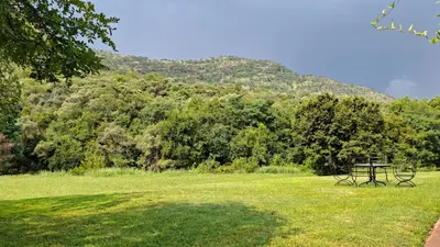 a picnic table in a field with a mountain in the background at Naledi-Africa in Centurion