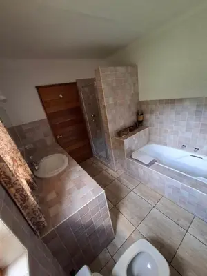 a bathroom with a tub and a toilet and a sink at Naledi-Africa in Centurion