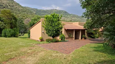 a house with a tree and a brick driveway at Naledi-Africa in Centurion