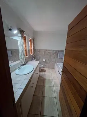 a bathroom with a sink and a toilet and a tub at Naledi-Africa in Centurion