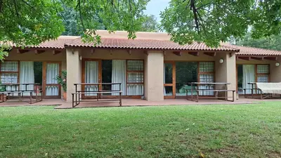 a building with benches and tables in a yard at Naledi-Africa in Centurion