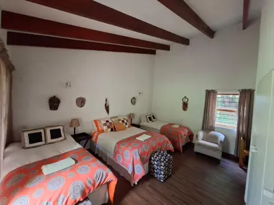 a bedroom with three beds and a chair and a window at Naledi-Africa in Centurion