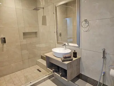a bathroom with a sink and a shower at Palms Erasmia in Centurion
