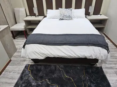 a bedroom with a large bed with a black rug at Palms Erasmia in Centurion