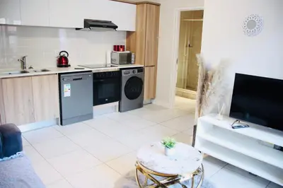 a kitchen with a washing machine and a table at The Blyde Crystal Lagoon Exclusive Apartment in Pretoria
