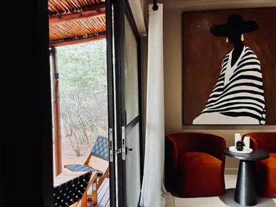 a room with a painting of a woman with a hat at Rhula Villa in Hoedspruit
