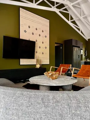 a living room with a table and a large screen at Rhula Villa in Hoedspruit
