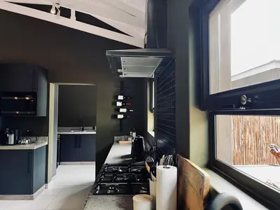 a kitchen with black cabinets and a stove top oven at Rhula Villa in Hoedspruit