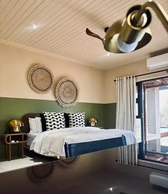 a bedroom with a bed and a ceiling at Rhula Villa in Hoedspruit