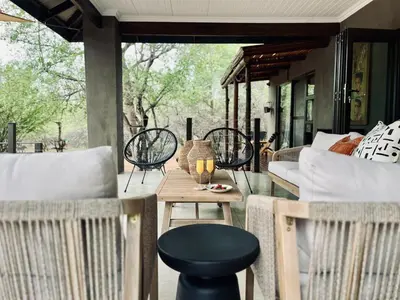 a patio with a table and chairs on a porch at Rhula Villa in Hoedspruit