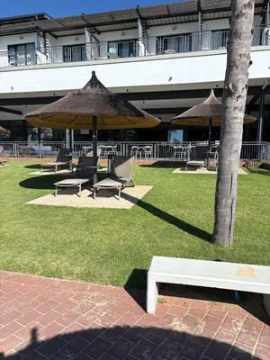 a group of chairs and umbrellas in a park at The Modern Stay At The Blyde in Pretoria