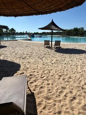 two chairs and an umbrella on a sandy beach at The Modern Stay At The Blyde in Pretoria
