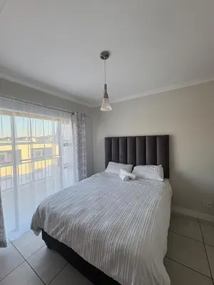 a bedroom with a large bed and a large window at The Modern Stay At The Blyde in Pretoria