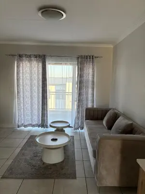 a living room with a couch and a table at The Modern Stay At The Blyde in Pretoria