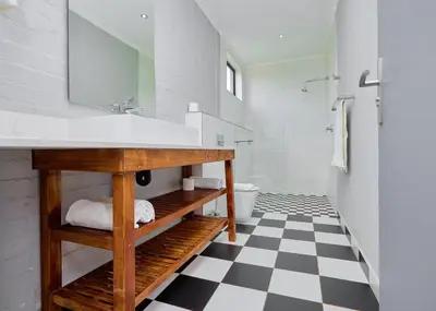 a bathroom with a sink and a black and white checkered floor at Brooklyn Modern Apartment Near Hatfield & Menlyn in Pretoria