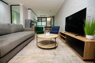 a living room with a couch and a flat screen tv at Brooklyn Modern Apartment Near Hatfield & Menlyn in Pretoria