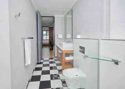 a bathroom with a black and white checkered floor at Brooklyn Modern Apartment Near Hatfield & Menlyn in Pretoria