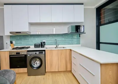 a kitchen with a washing machine and a sink at Brooklyn Modern Apartment Near Hatfield & Menlyn in Pretoria