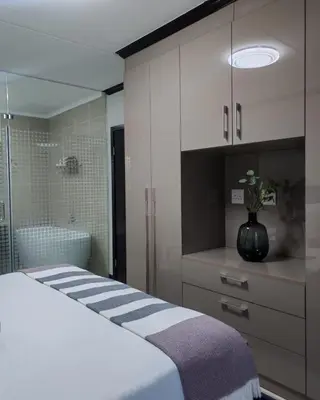 a bedroom with a bed and a bathroom with a tub at Walford Prestige Apartment - by Global Links Properties in Midrand